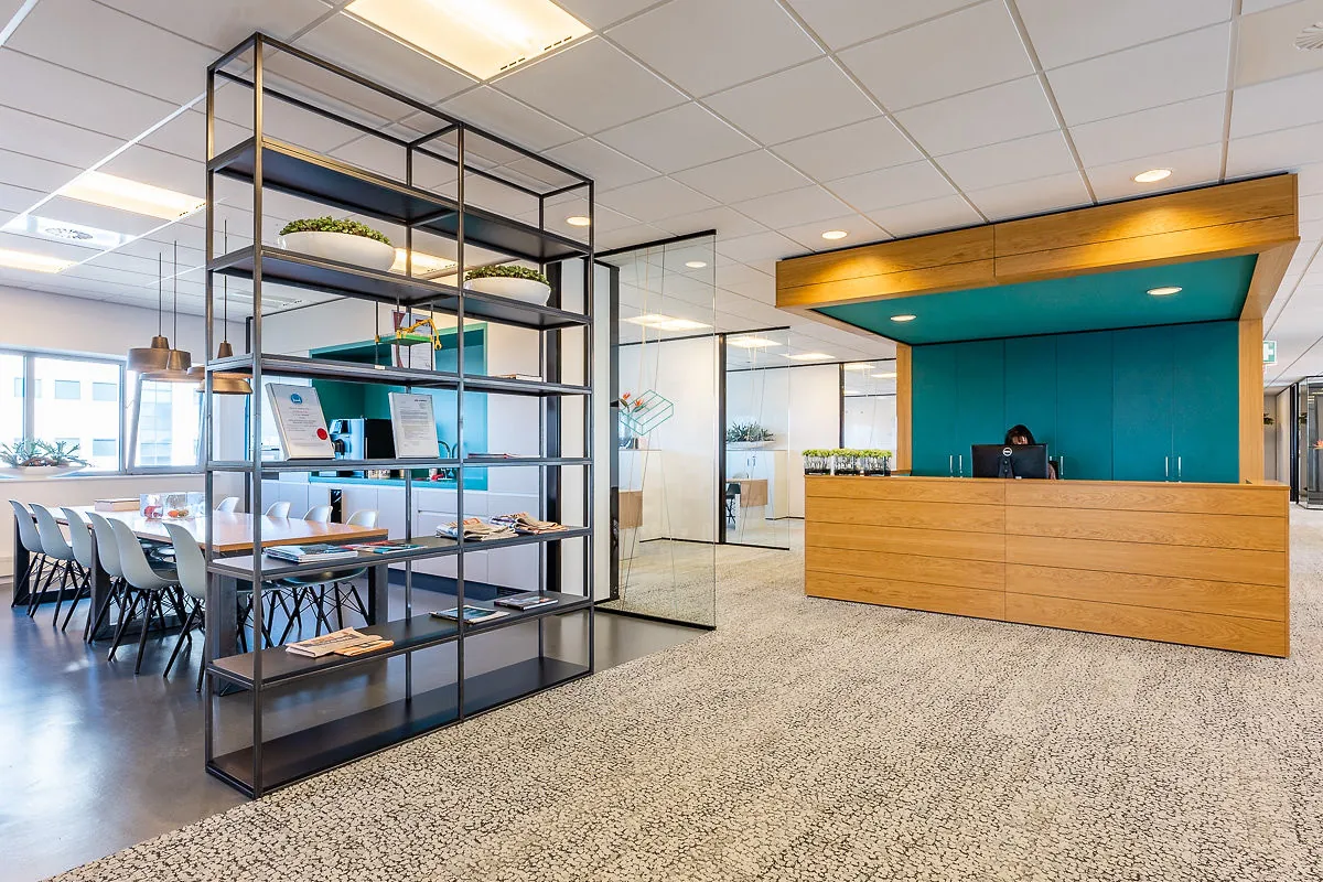 Moderne kantoorruimte in Rivium Quadrant met een receptiebalie, vergaderruimte en open stellingkast.